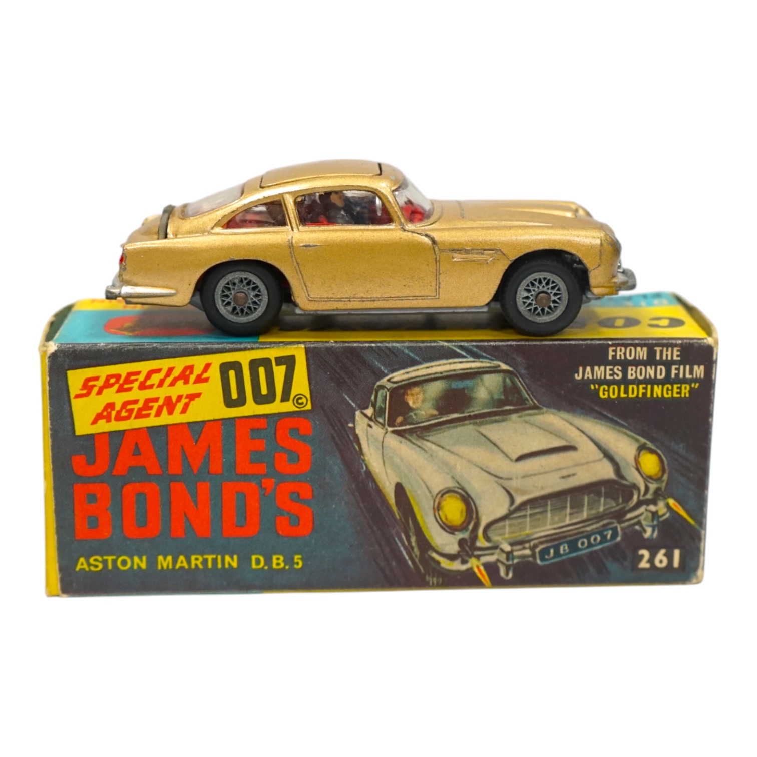 A Corgi Toys (261) James Bond 007 Aston Martin in gold, together with its original box, card display stand, secret instructions and envelope, and an additional spare passenger. Condition fair to good, minor chips to the